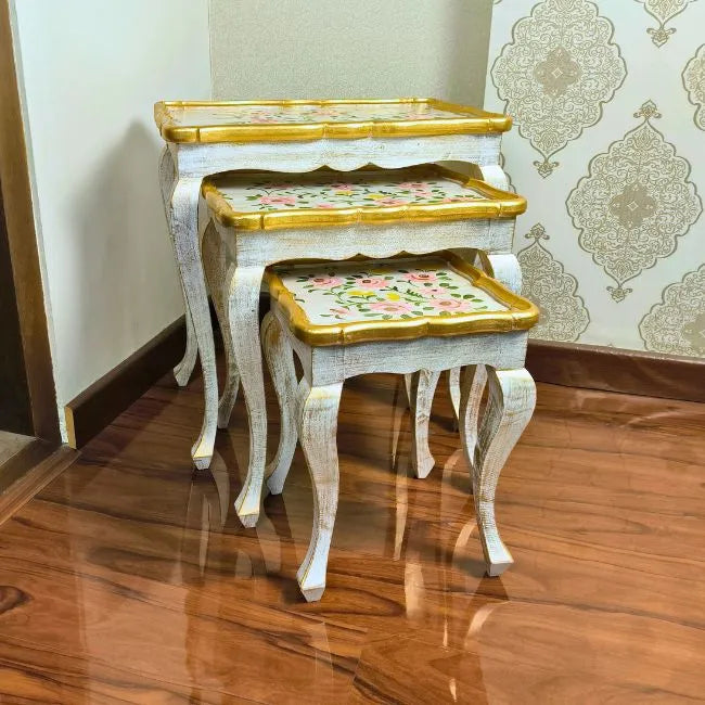 Close-up of Pink Rose nesting tables, highlighting the delicate hand-painted pink floral artwork on a distressed white wooden surface.