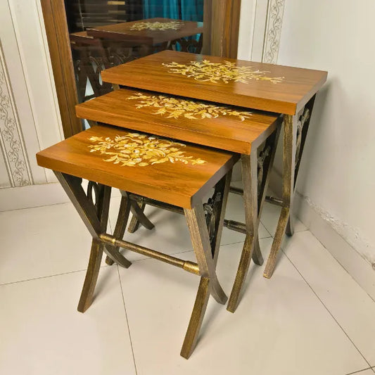 Space-saving Rustic Harmony nesting tables stacked together, featuring a warm woodgrain surface with gold floral detailing